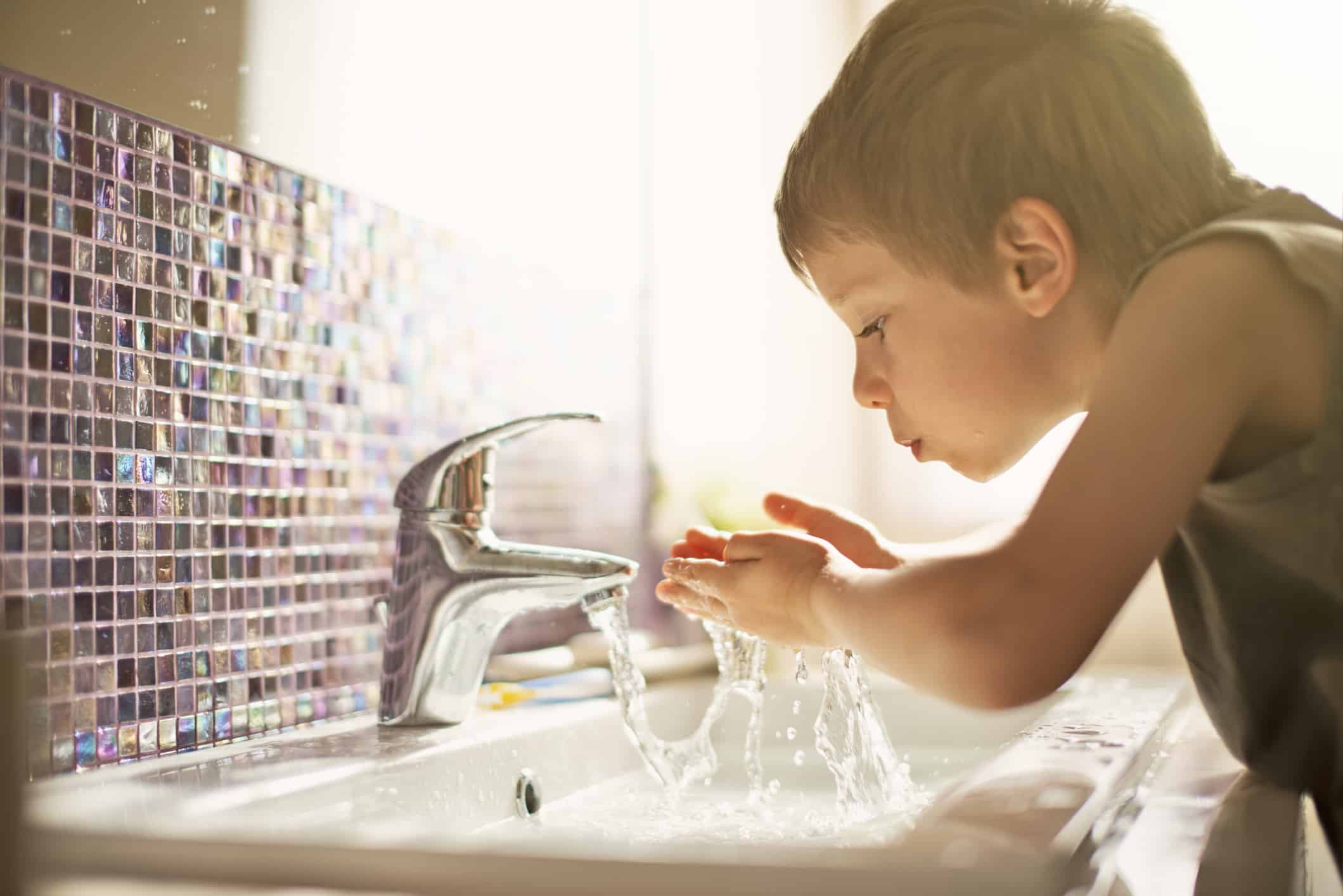 Little boy drinking tap water