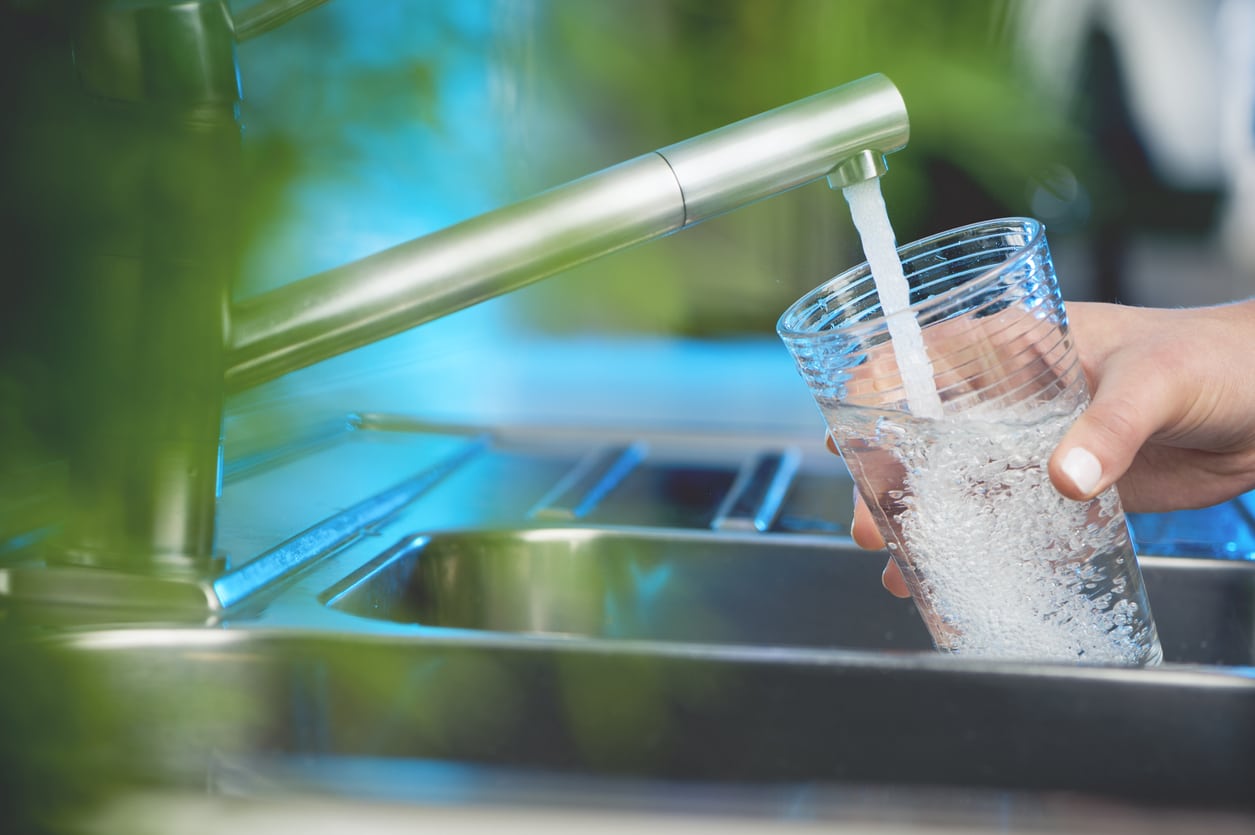 Woman filling a glass of water.